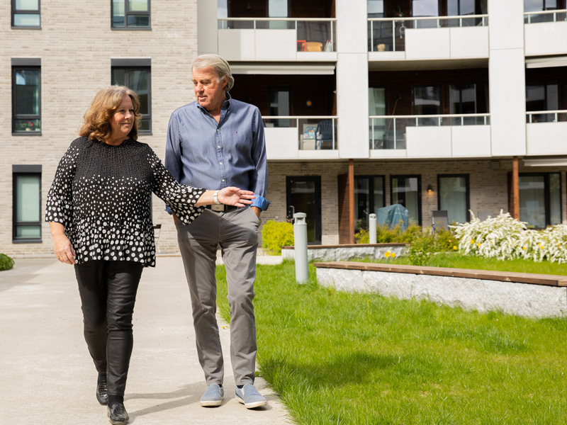 Fasdebilde av boligblokkene i Strømmen Verksted, vinter, snø og lys i vinduene.