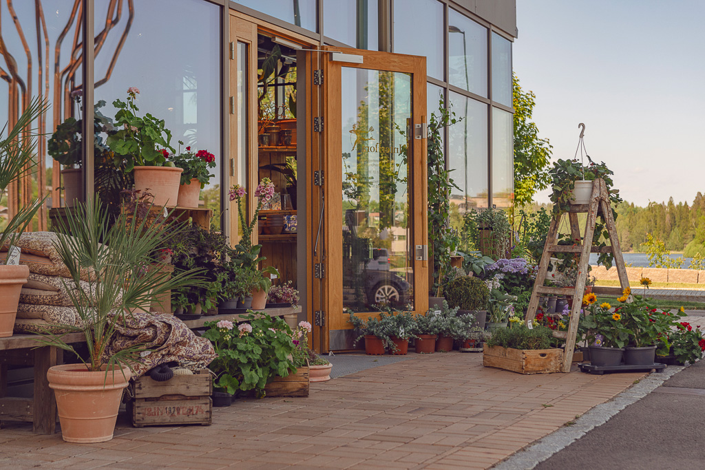 Fasaden til en blomsterbutikk, med mengder av blomster utstilt på gata. Foto fra Heggedal sentrum.