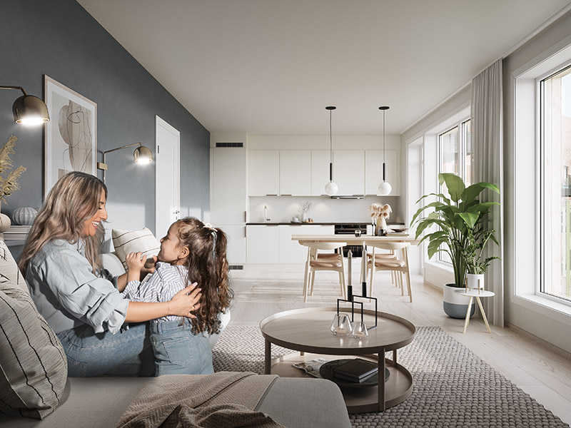 Interiørbilde av stue i Skårerløkka boligprosjekt. En mor som sitter på sofaen og har selskap av sin datter. Lys og fin stue med lyse møbler og mye naturlig lys fra vinduene.