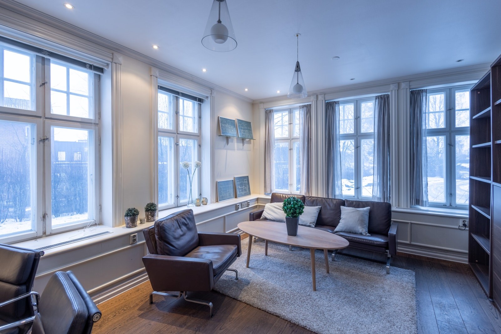 Samme kontorrom med sittegruppe i romslig kontor med flere vindusflater som gir godt dagslys og en behagelig arbeidsatmosfære.